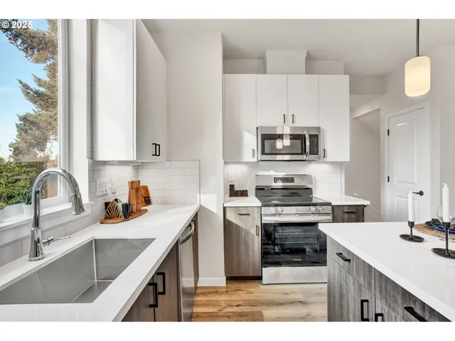 a kitchen with kitchen island a sink stove top oven and microwave