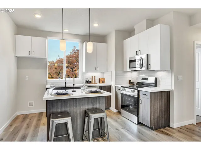 a kitchen with kitchen island granite countertop a sink appliances cabinets and a counter top space