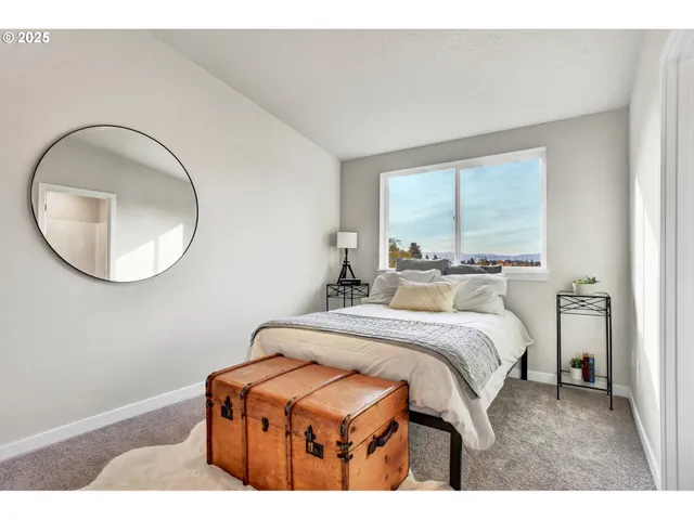 a bedroom with a bed mirror and window