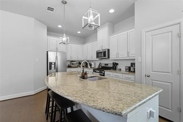 a kitchen with kitchen island a sink refrigerator and microwave