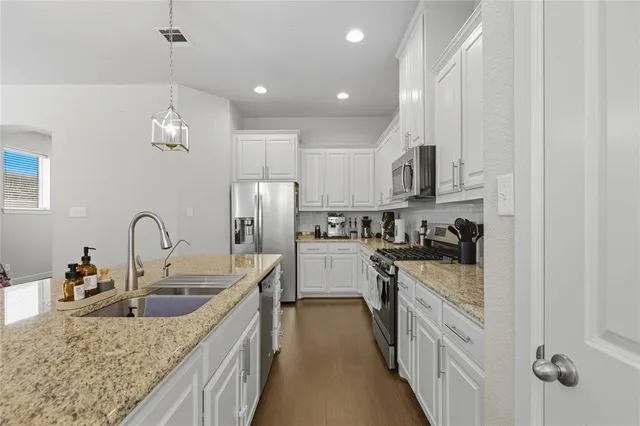 a kitchen with stainless steel appliances granite countertop a sink stove and refrigerator