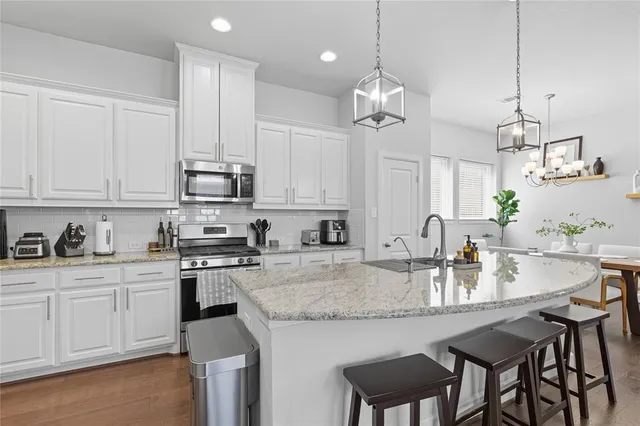a kitchen with kitchen island granite countertop a sink a center island and cabinets