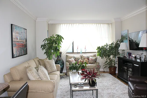 a living room with furniture a window and a flat screen tv