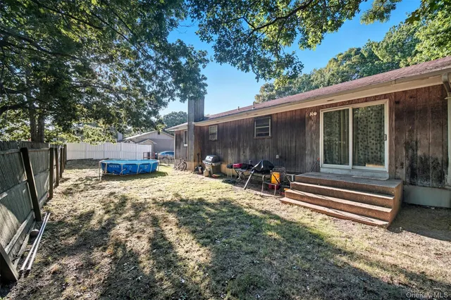 a view of backyard with table and chairs and a large tree