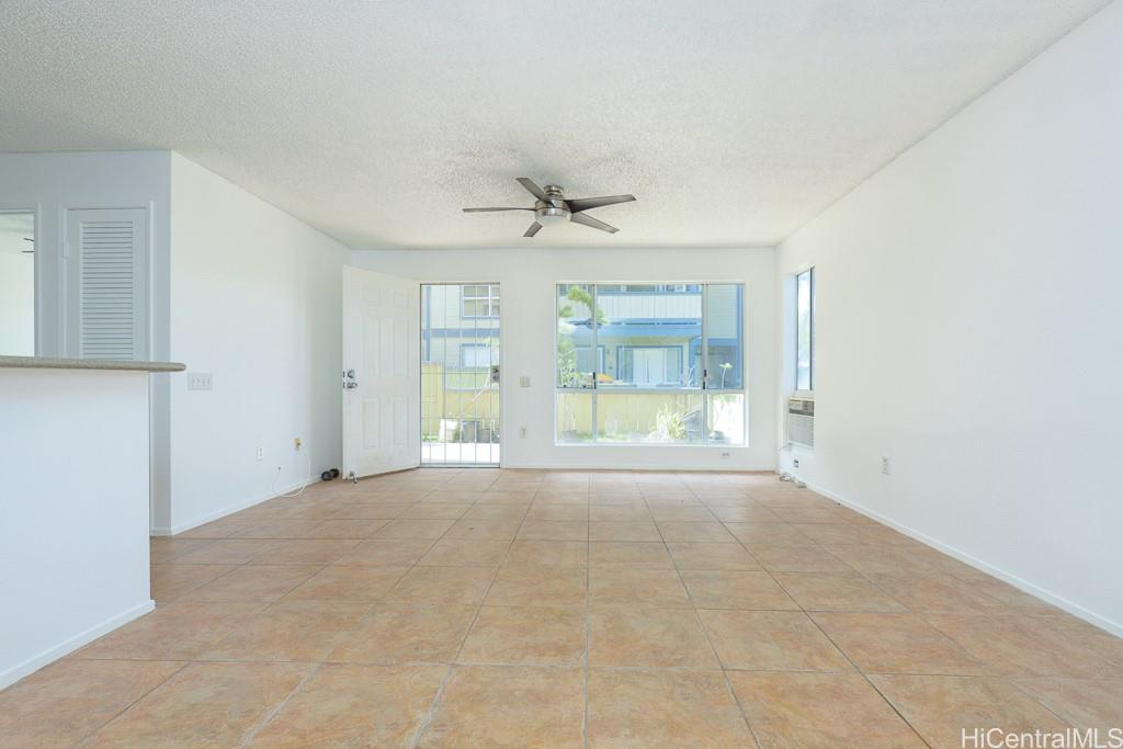 an empty room with a ceiling fan and windows