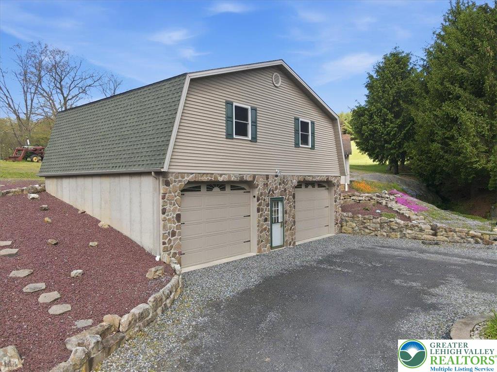 4880 Little Gap Road Kunkletown, PA 18058 - Photo 59 of 100 This structure features a unique design with a prominent gambrel roof and a durable stone facade.