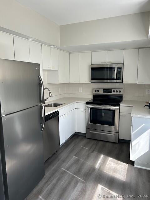 a kitchen with stainless steel appliances a refrigerator stove and white cabinets