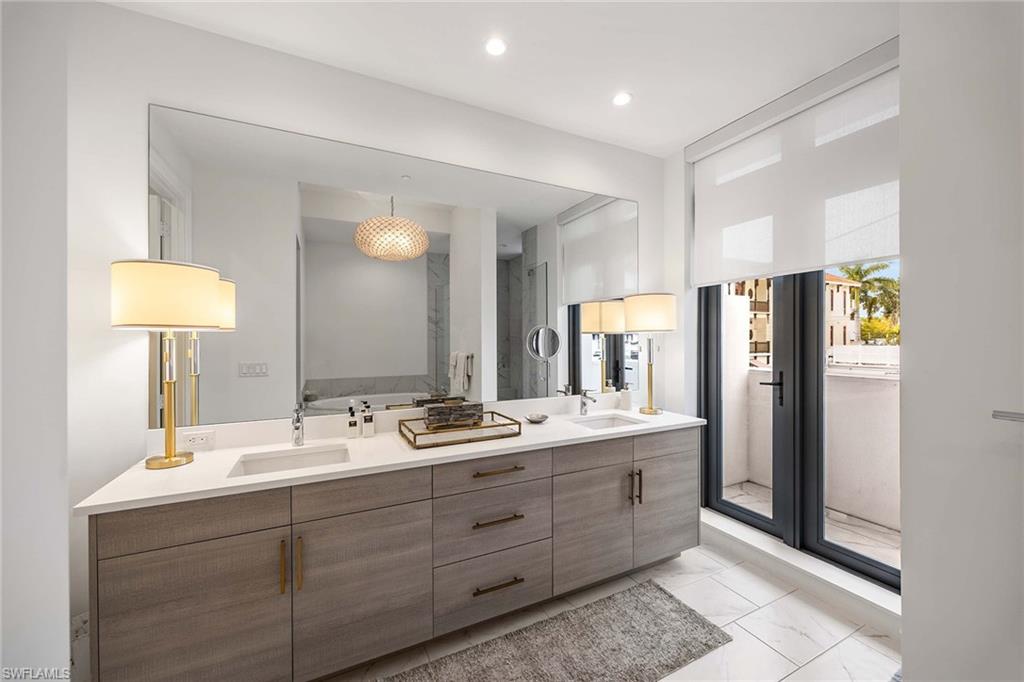 875 6th Avenue South, Unit 203 Naples, FL 34102 - Photo 9 of 49 Beautifully appointed primary bath showcasing a double vanity and serene, spa-like design.
