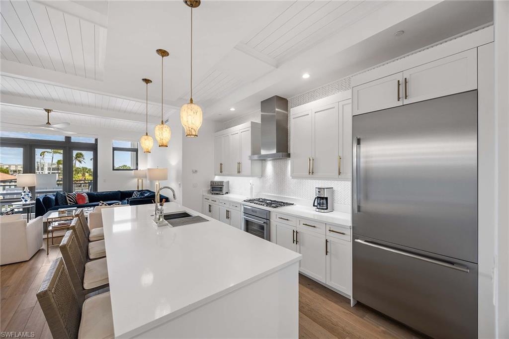 875 6th Avenue South, Unit 203 Naples, FL 34102 - Photo 16 of 49 Chef’s kitchen featuring Thermador appliances, Arctic white quartz countertops, and a generous center island.