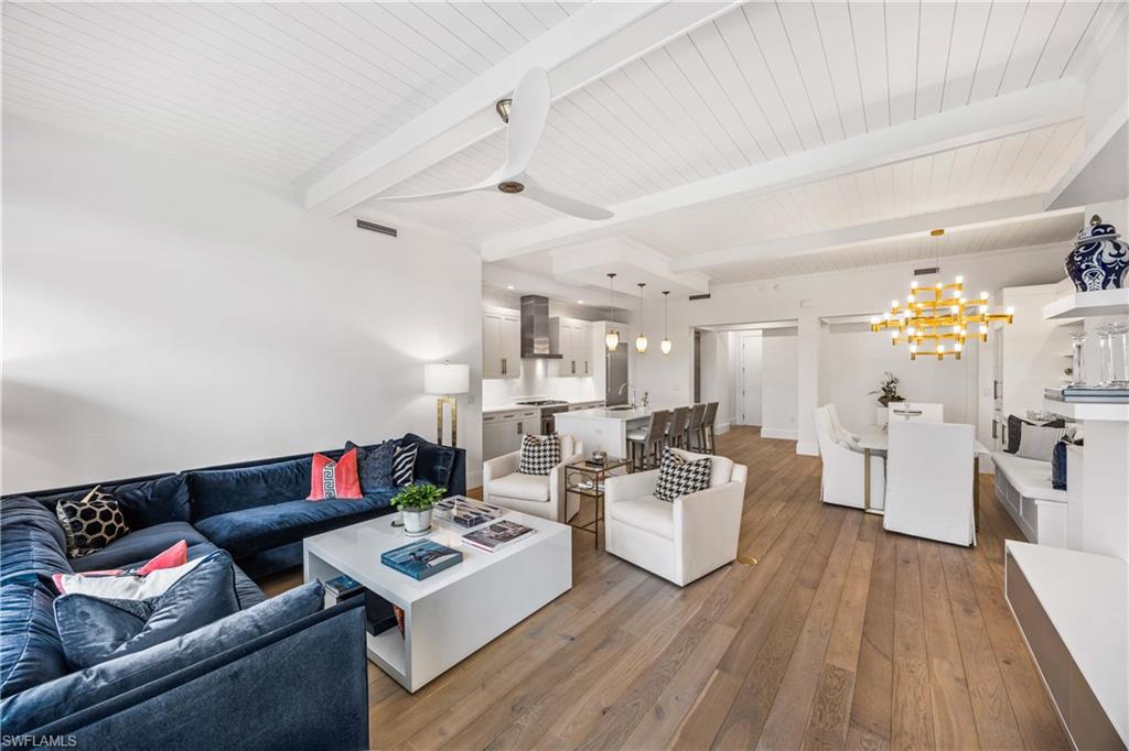 875 6th Avenue South, Unit 203 Naples, FL 34102 - Photo 18 of 49 Living room featuring a chandelier, dark wood-style flooring, a wooden ceiling with exposed beams, and ceiling fan