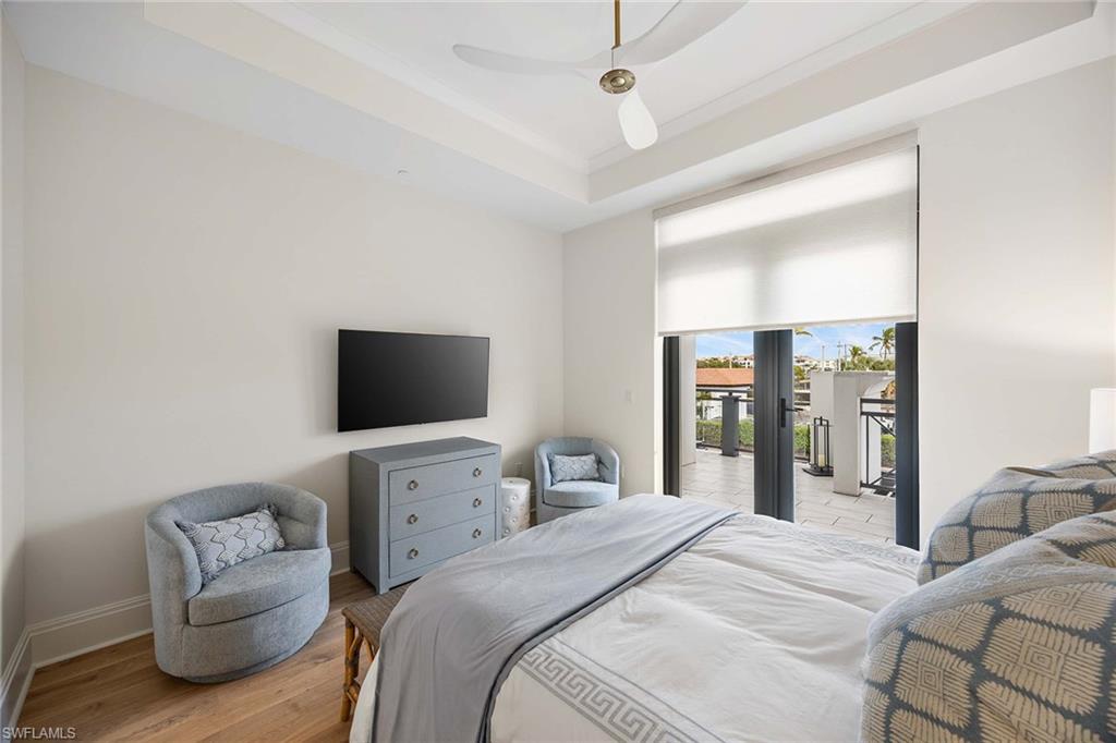 875 6th Avenue South, Unit 203 Naples, FL 34102 - Photo 29 of 49 Serene guest bedroom suite showcasing designer finishes and private lanai access for indoor-outdoor living.