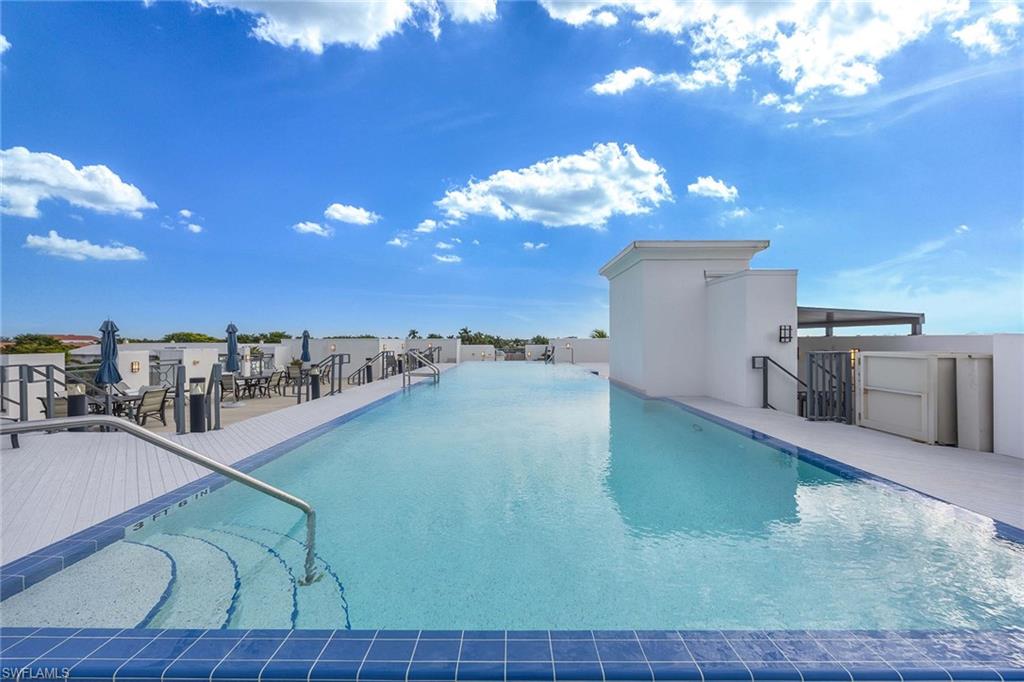 875 6th Avenue South, Unit 203 Naples, FL 34102 - Photo 37 of 49 Resort-style rooftop pool with city views, lounge seating, and an elevated downtown atmosphere.