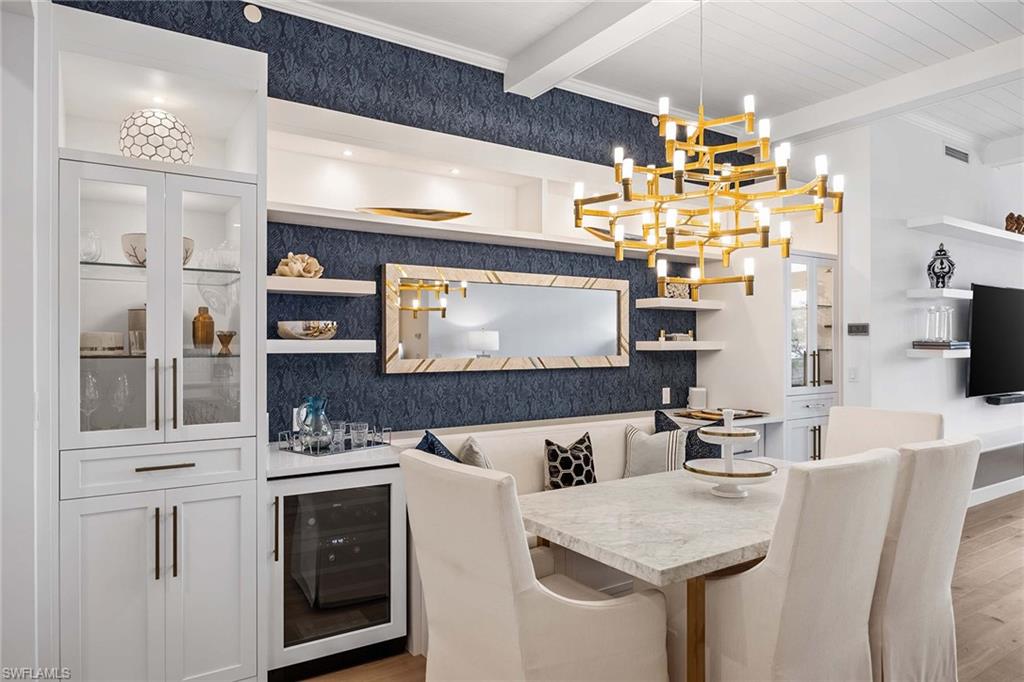 875 6th Avenue South, Unit 203 Naples, FL 34102 - Photo 2 of 49 Custom dining space anchored by a built-in banquet, wine refrigerator, dual refrigerator drawers, and bespoke cabinetry.