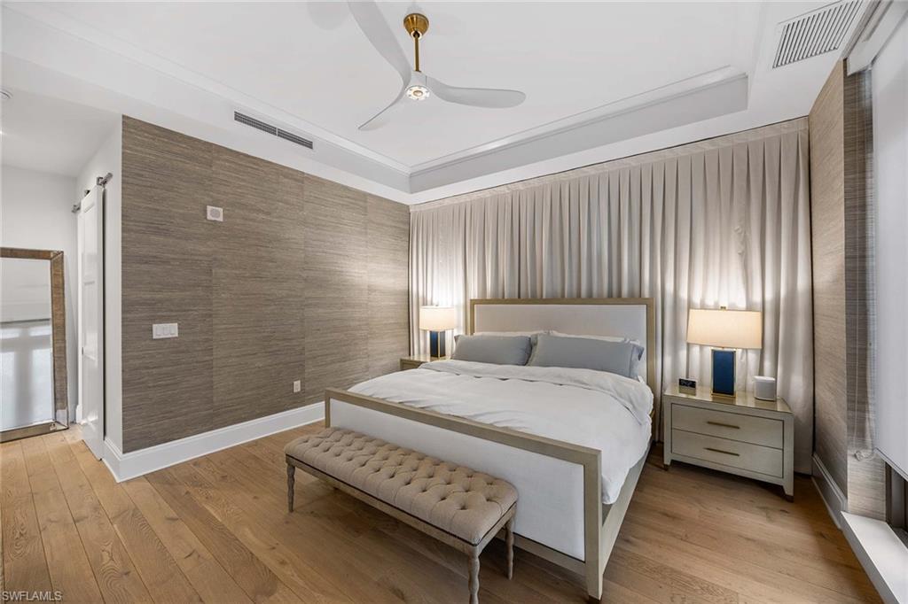 875 6th Avenue South, Unit 203 Naples, FL 34102 - Photo 8 of 49 Serene primary bedroom featuring high-end Matouk bedding and refined designer finishes.