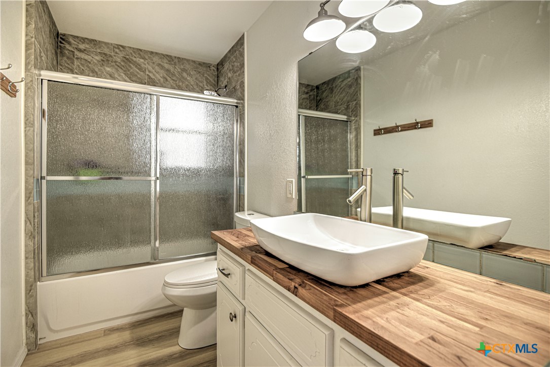 8510 Burgandy Lane Temple, TX 76504 - Photo 16 of 48 a bathroom with a granite countertop sink toilet a mirror and shower
