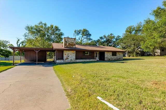 a front view of a house with a yard and trees
