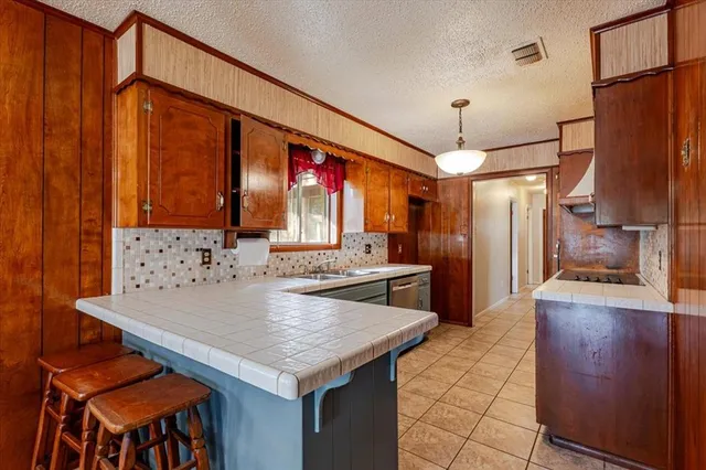 a kitchen with granite countertop a table chairs and a refrigerator