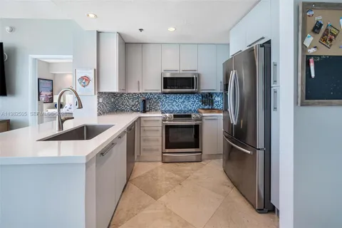 a kitchen with stainless steel appliances granite countertop a refrigerator and a sink