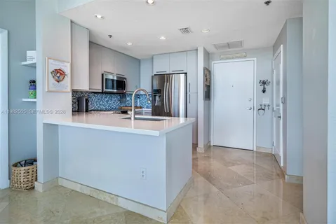 a kitchen with stainless steel appliances a sink and refrigerator