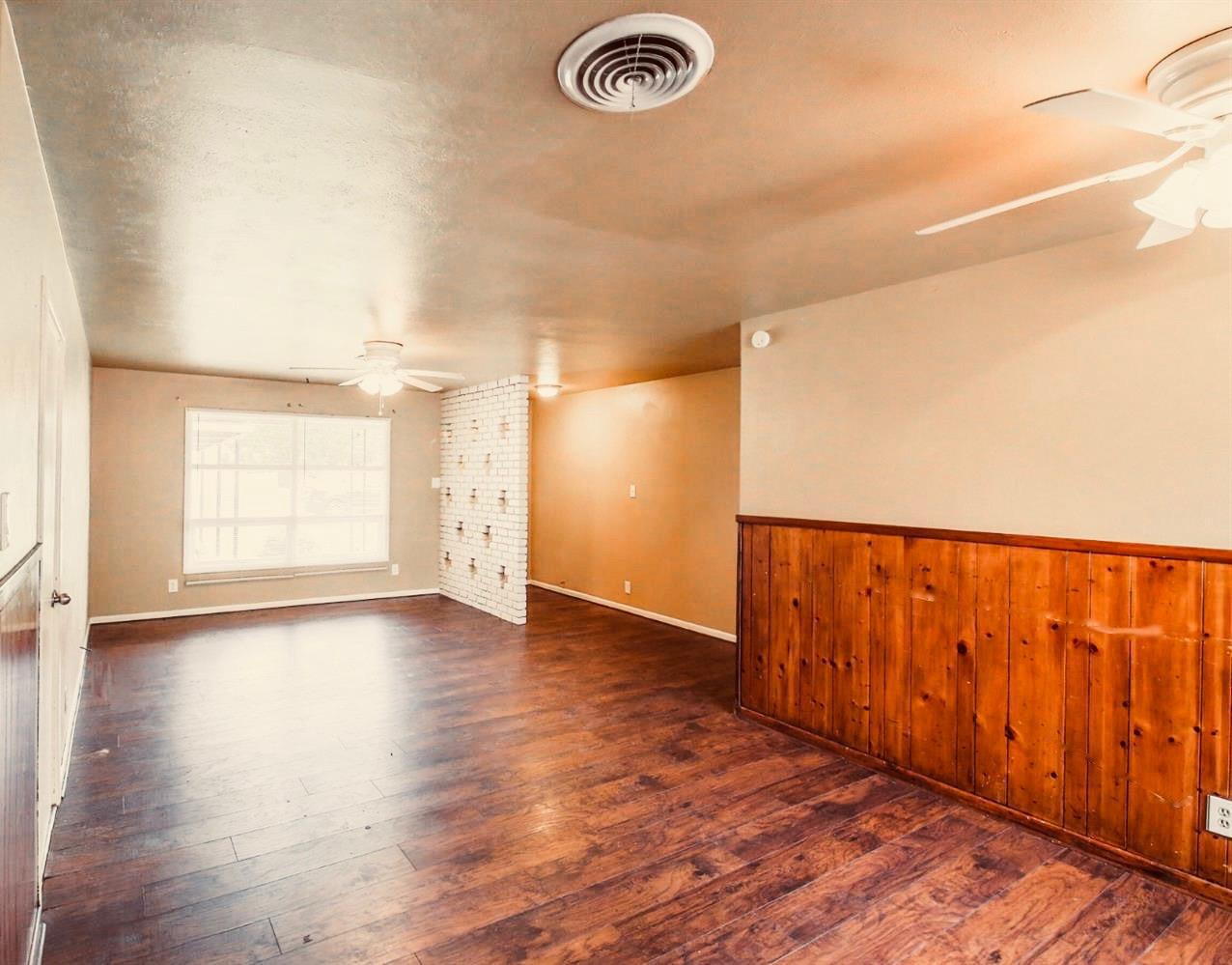 3809 25th Street Lubbock, TX 79410 - Photo 2 of 8 a view of an empty room with wooden floor and a window