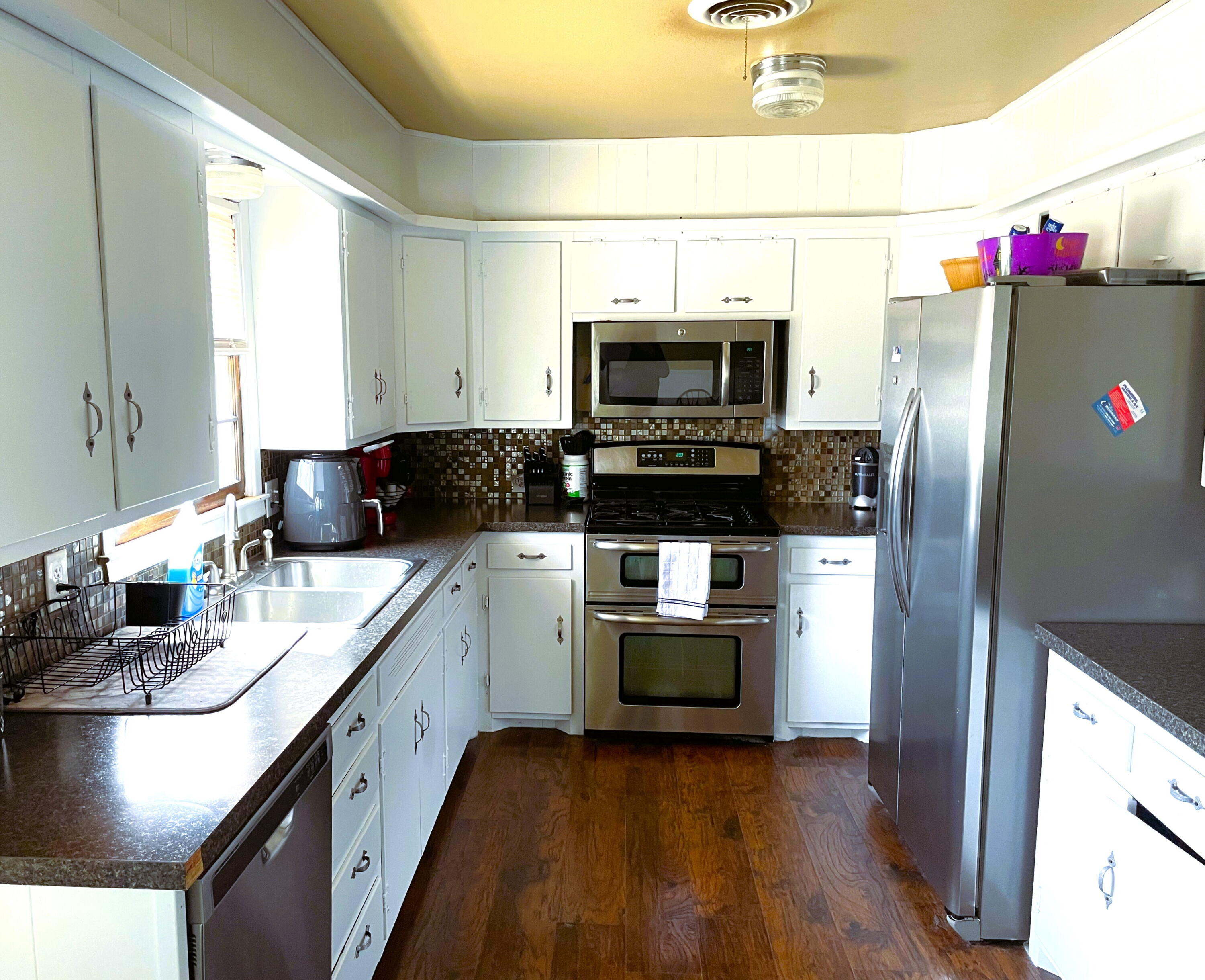 3809 25th Street Lubbock, TX 79410 - Photo 3 of 8 a kitchen with granite countertop a refrigerator stove and microwave