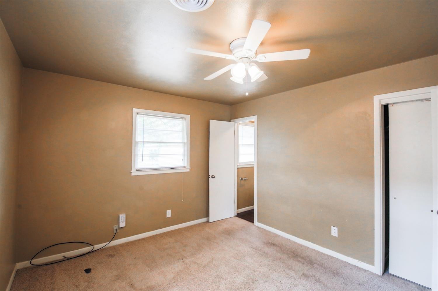 3809 25th Street Lubbock, TX 79410 - Photo 6 of 8 an empty room with a fan & a window
