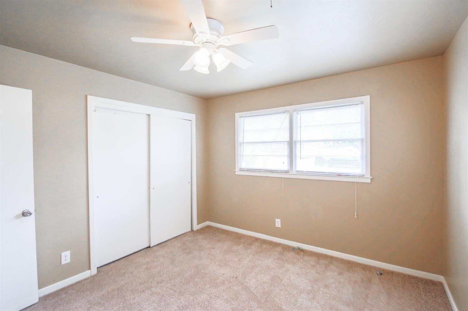3809 25th Street Lubbock, TX 79410 - Photo 8 of 8 an empty room with windows and fan
