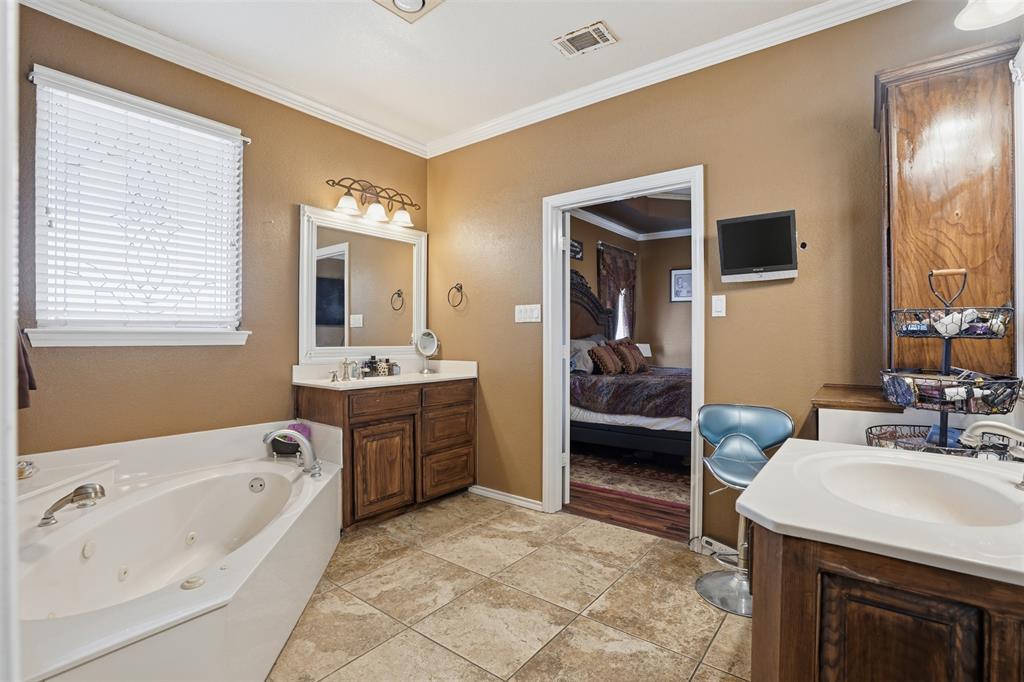 7229 County Road 1205 Rio Vista, TX 76093 - Photo 15 of 40 a en suite spacious bathroom with a granite countertop tub and a sink