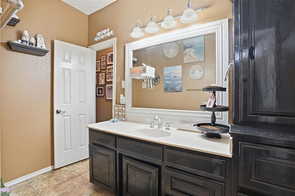 7229 County Road 1205 Rio Vista, TX 76093 - Photo 20 of 40 a bathroom with a sink vanity and a mirror