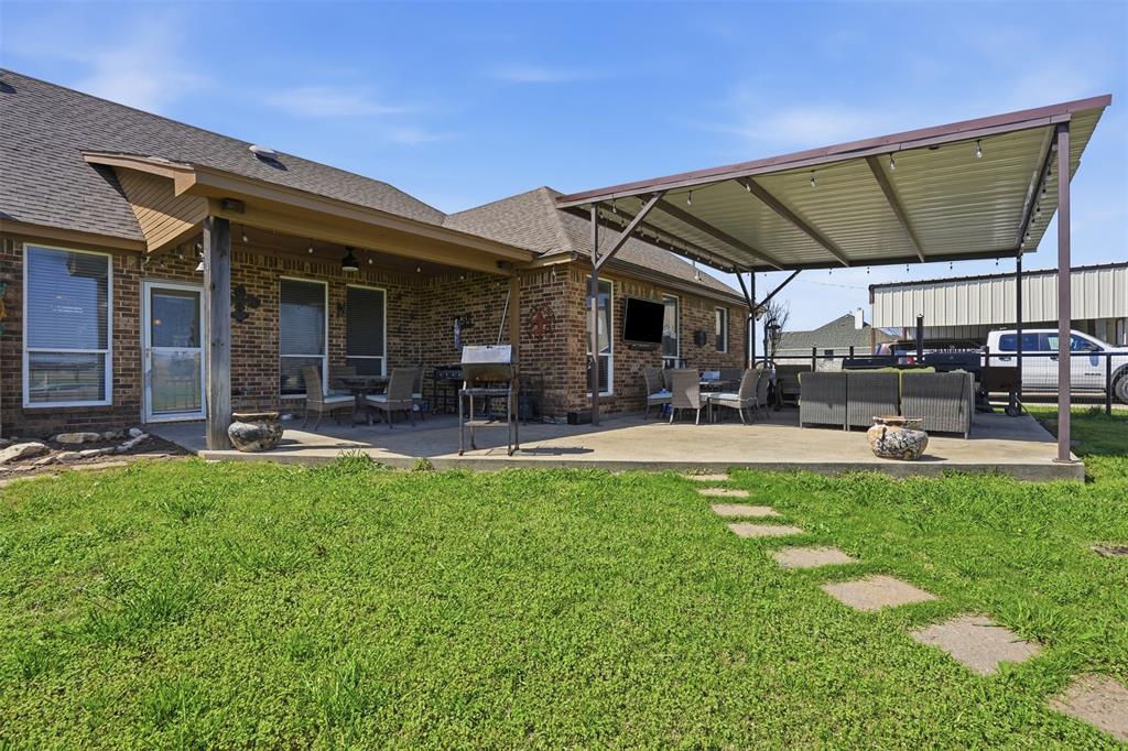 7229 County Road 1205 Rio Vista, TX 76093 - Photo 24 of 40 a view of a patio with table and chairs under an umbrella