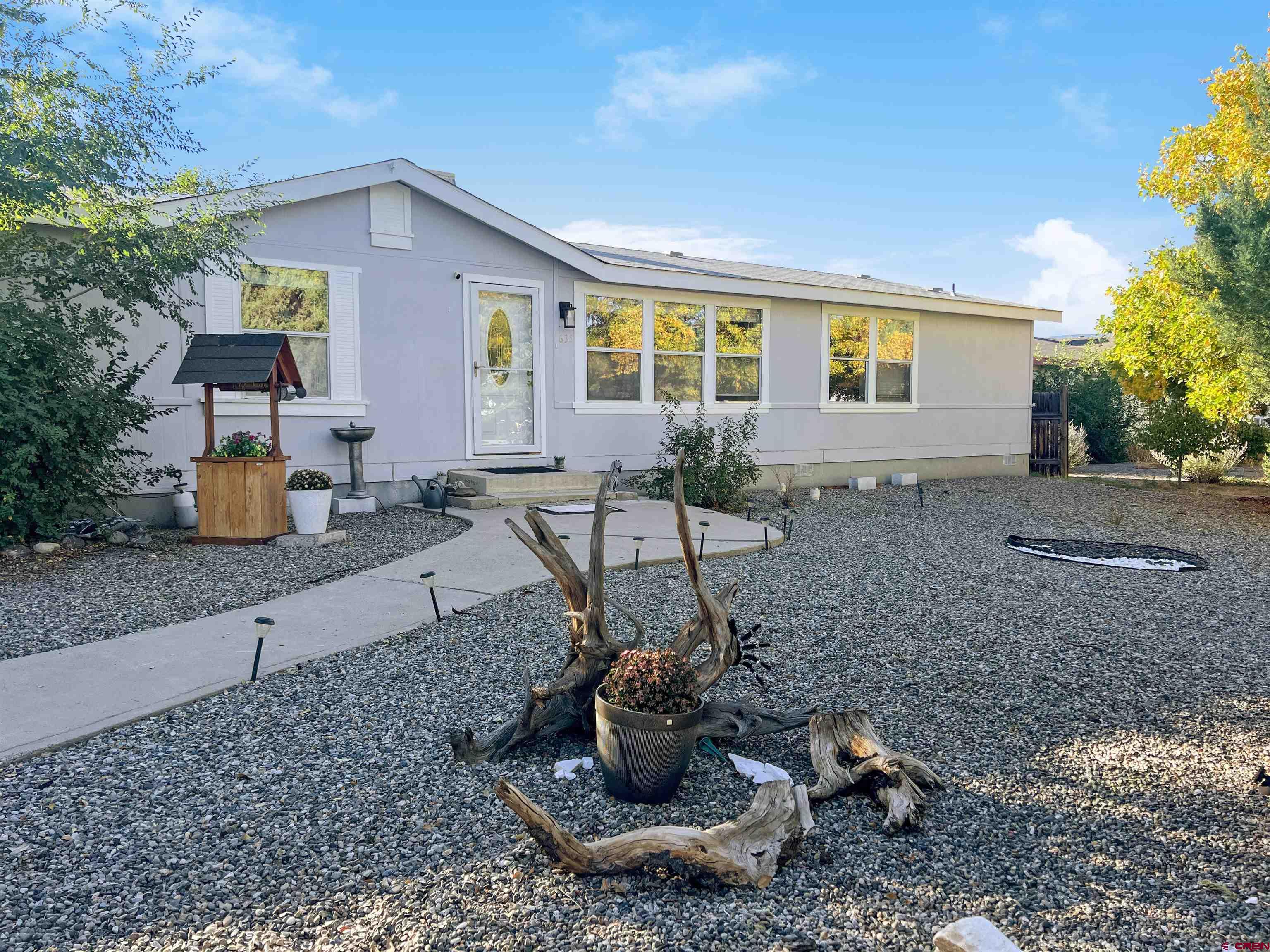 635 Fox Court Delta, CO 81416 - Photo 2 of 22 a view of a backyard with table and chairs potted plants and large tree