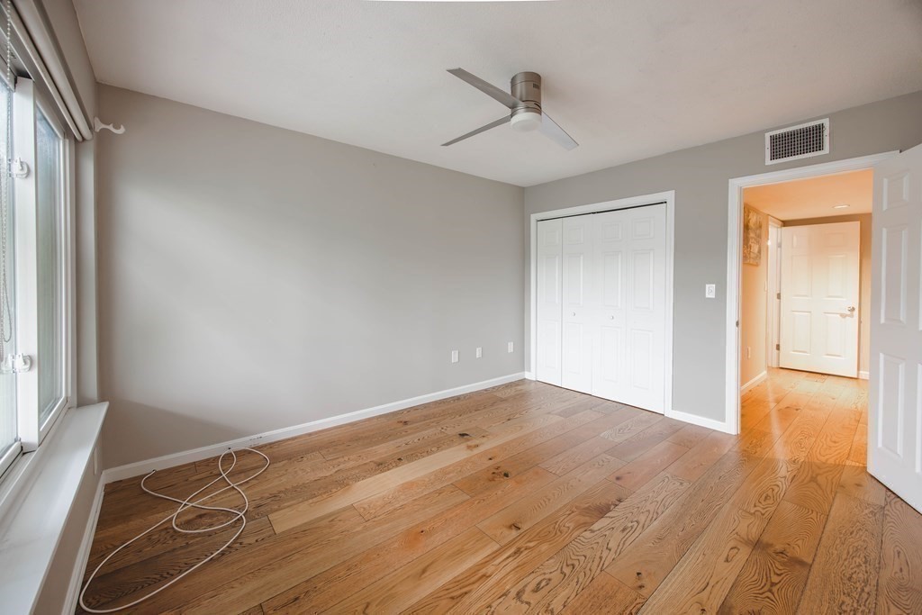 59 Brainerd Road, Unit 407 Boston, MA 02134 - Photo 12 of 22 a view of an empty room with wooden floor and a window