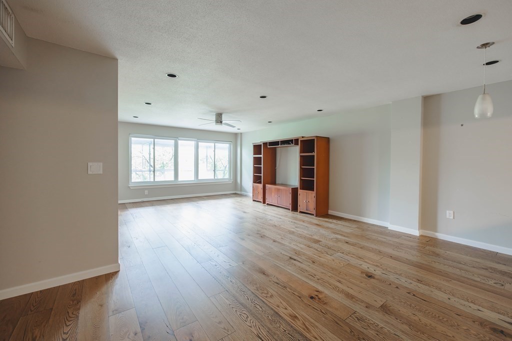 59 Brainerd Road, Unit 407 Boston, MA 02134 - Photo 6 of 22 an empty room with wooden floor and windows