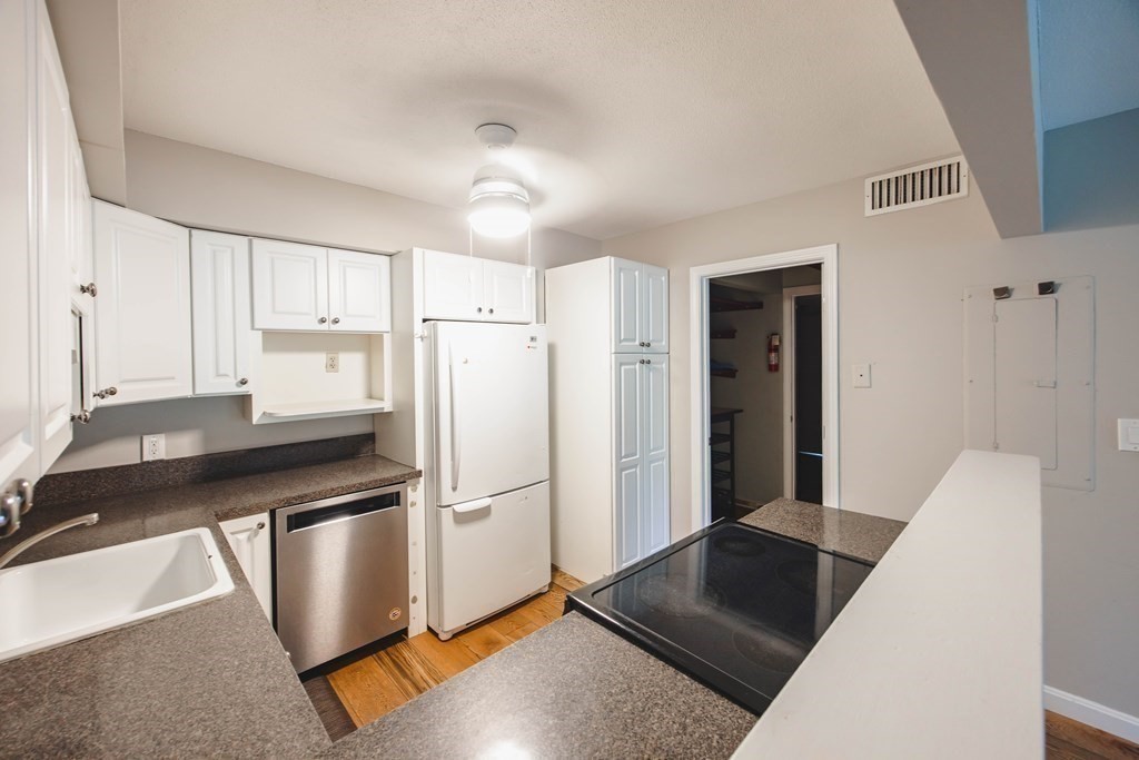 59 Brainerd Road, Unit 407 Boston, MA 02134 - Photo 10 of 22 a kitchen with granite countertop a refrigerator and a sink