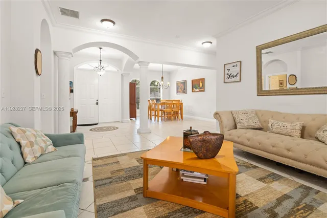 a living room with furniture and a chandelier