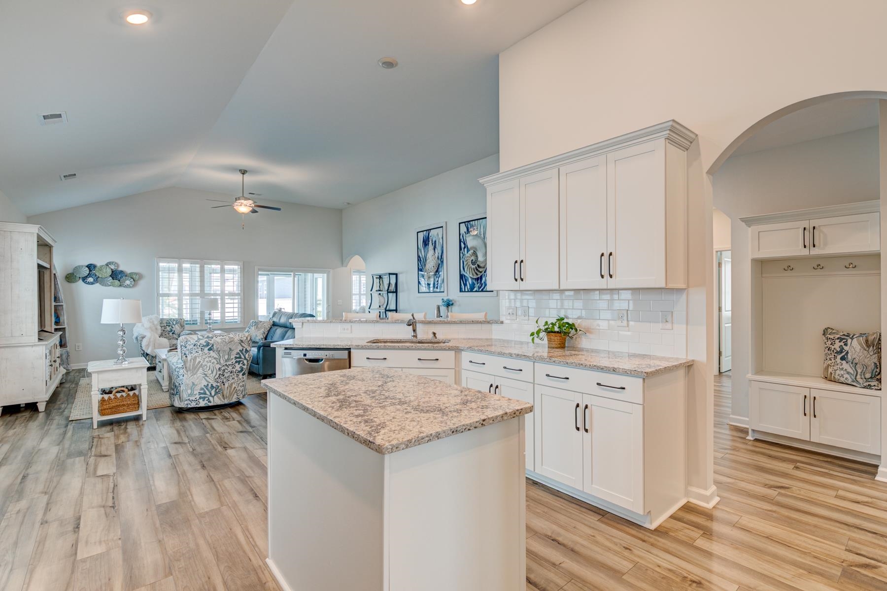 417 Heathside Street Murrells Inlet, SC 29576 - Photo 40 of 40 Kitchen featuring arched walkways, white cabinets, a peninsula, open floor plan, and light wood finished floors