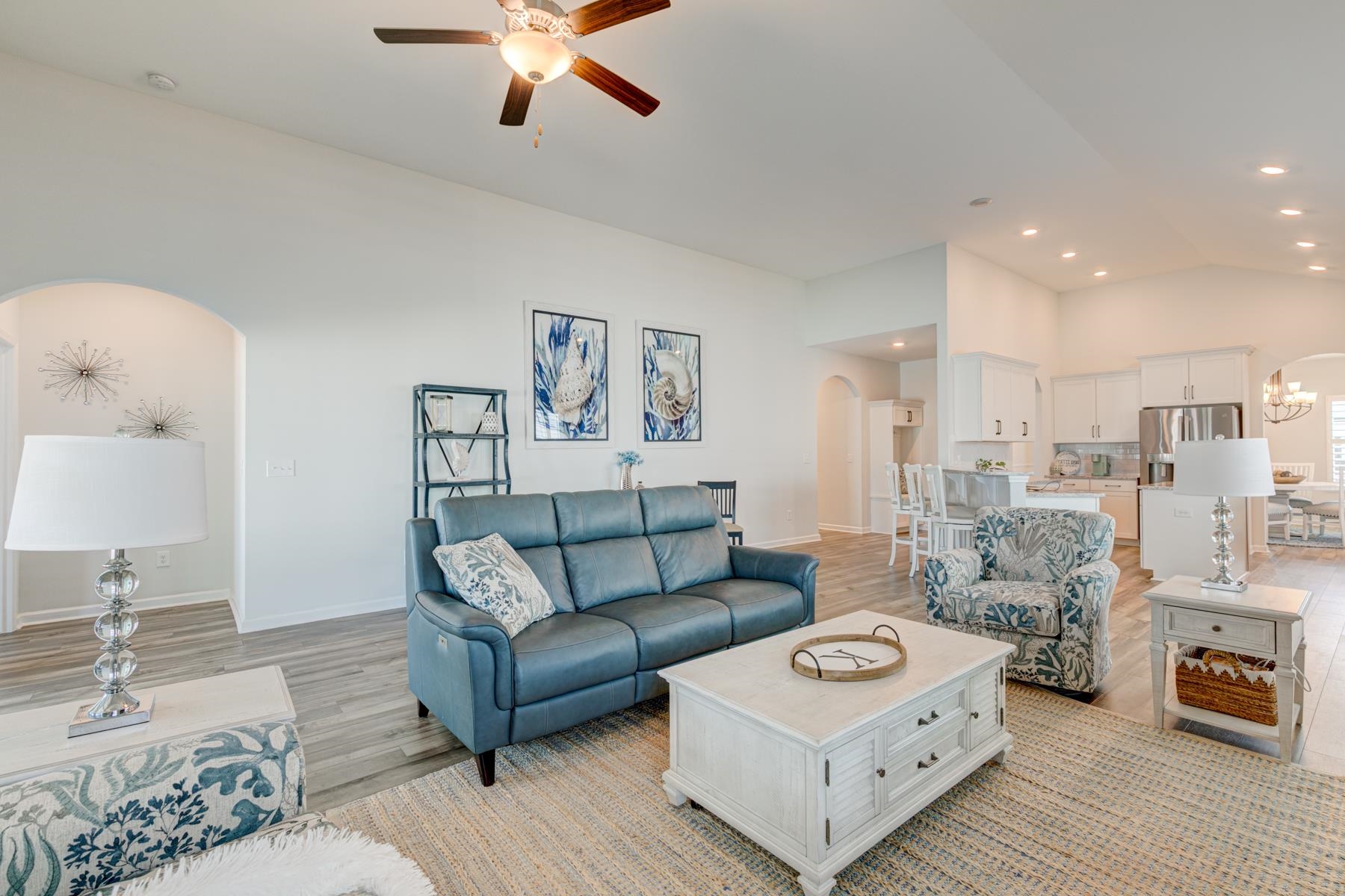 417 Heathside Street Murrells Inlet, SC 29576 - Photo 13 of 40 Living area featuring arched walkways, light wood-type flooring, vaulted ceiling, a chandelier, and ceiling fan