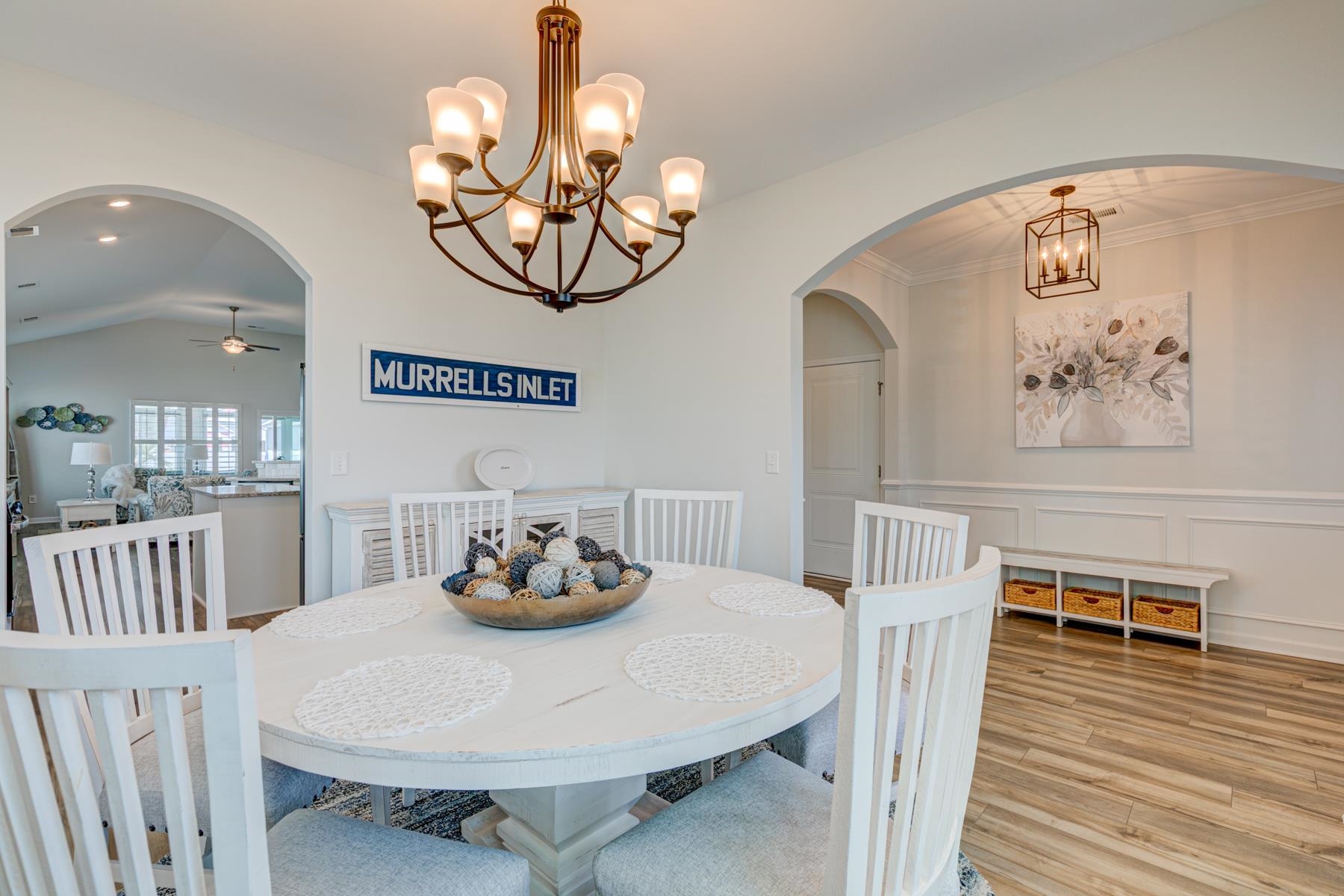 417 Heathside Street Murrells Inlet, SC 29576 - Photo 6 of 40 Dining space featuring arched walkways, a chandelier, wood finished floors, ceiling fan, and a decorative wall