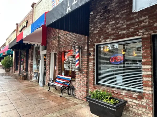 a brick building with a small yard and potted plants