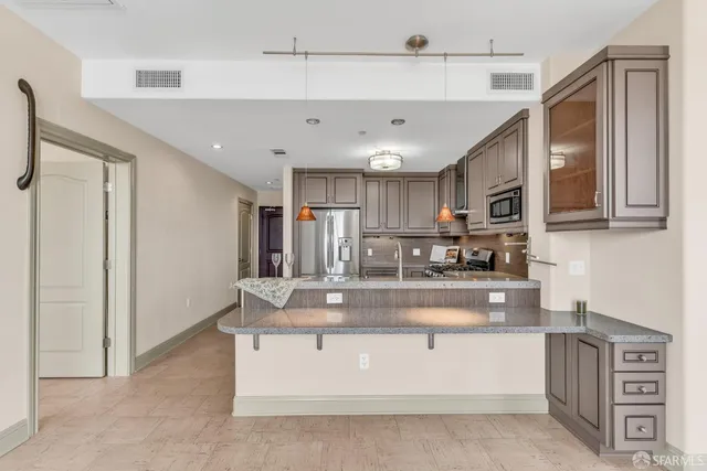 a kitchen with stainless steel appliances granite countertop a stove a sink and a microwave