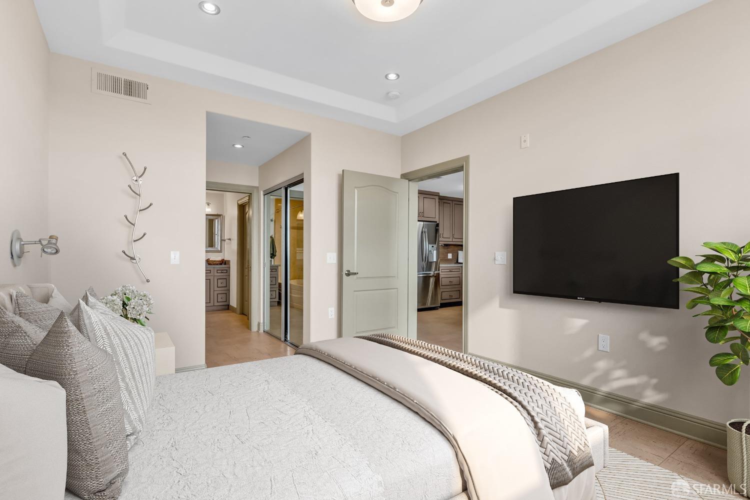 151 El Camino Real, Unit 402 Millbrae, CA 94030 - Photo 27 of 43 a bedroom with a bed and a flat screen tv