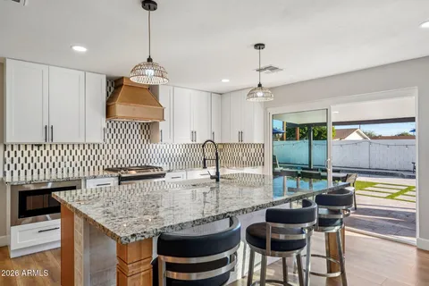 a kitchen with granite countertop white cabinets and white appliances