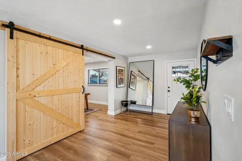 a living room with furniture a mirror and a wooden floor