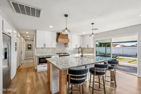 a bedroom with a large bed and a chandelier fan