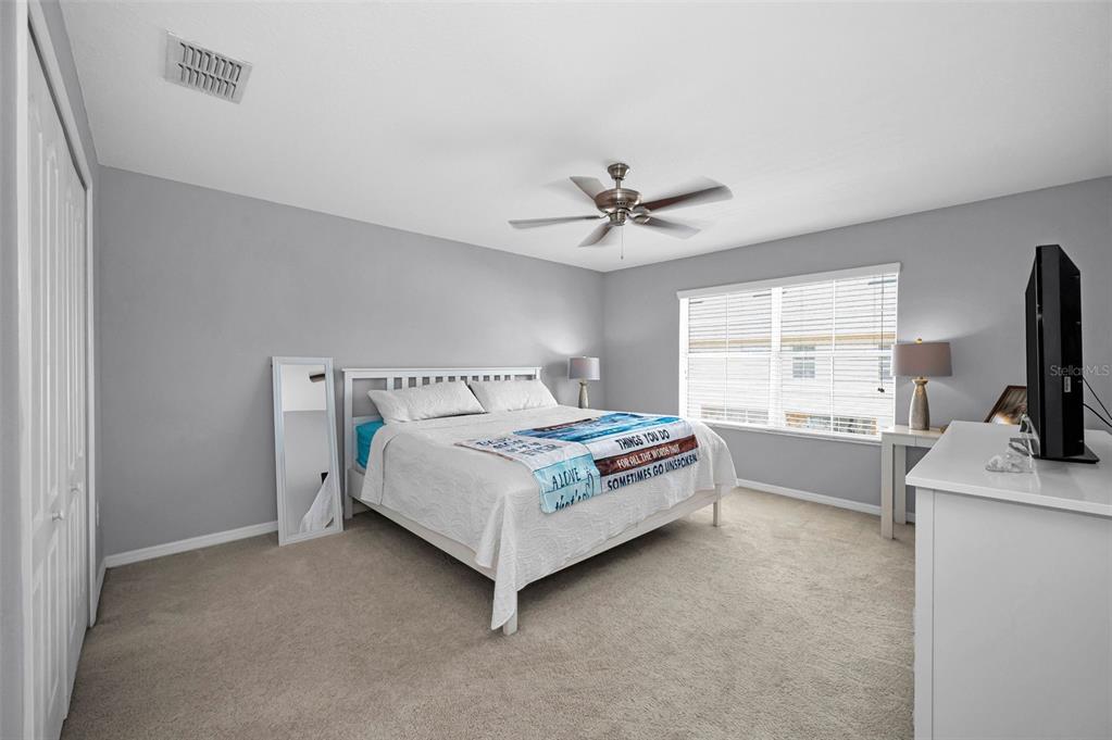 9736 Trumpet Vine Loop Trinity, FL 34655 - Photo 6 of 35 a bedroom with a bed a window and a flat screen television