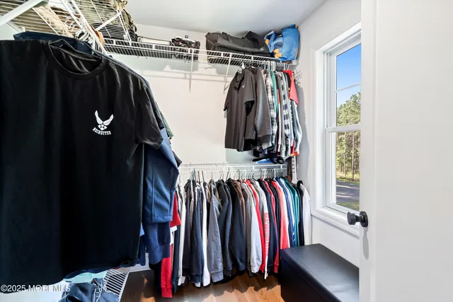 a view of walk in closet with clothes