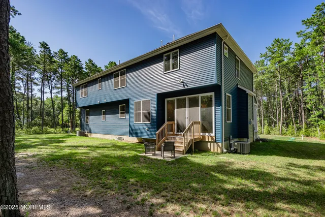 an aerial view of residential houses with outdoor space and trees