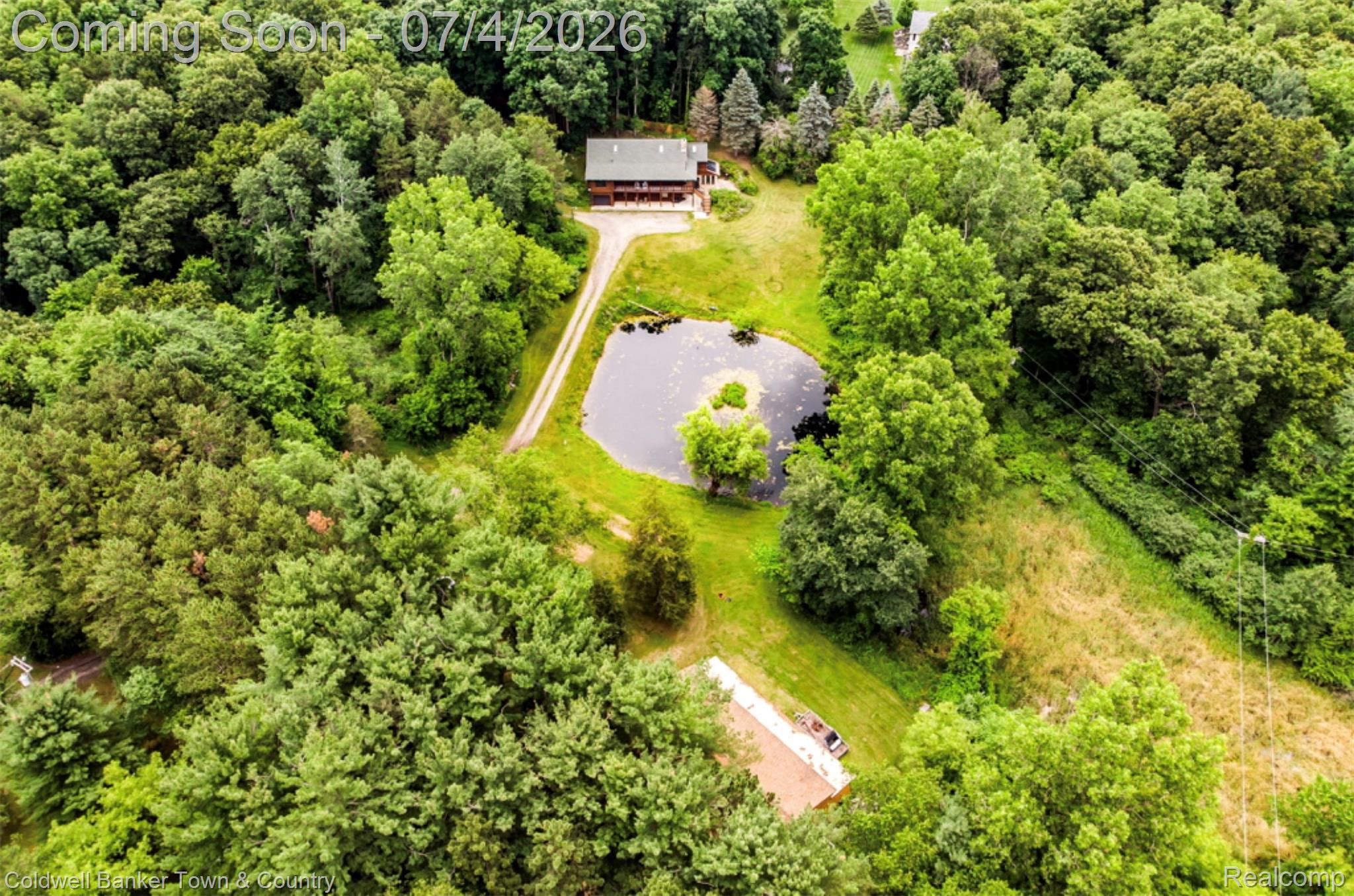 7335 Richardson Road Howell, MI 48843 - Photo 50 of 54 Expansive natural landscape featuring a private pond, mature trees, and a secluded residence with a substantial surrounding property