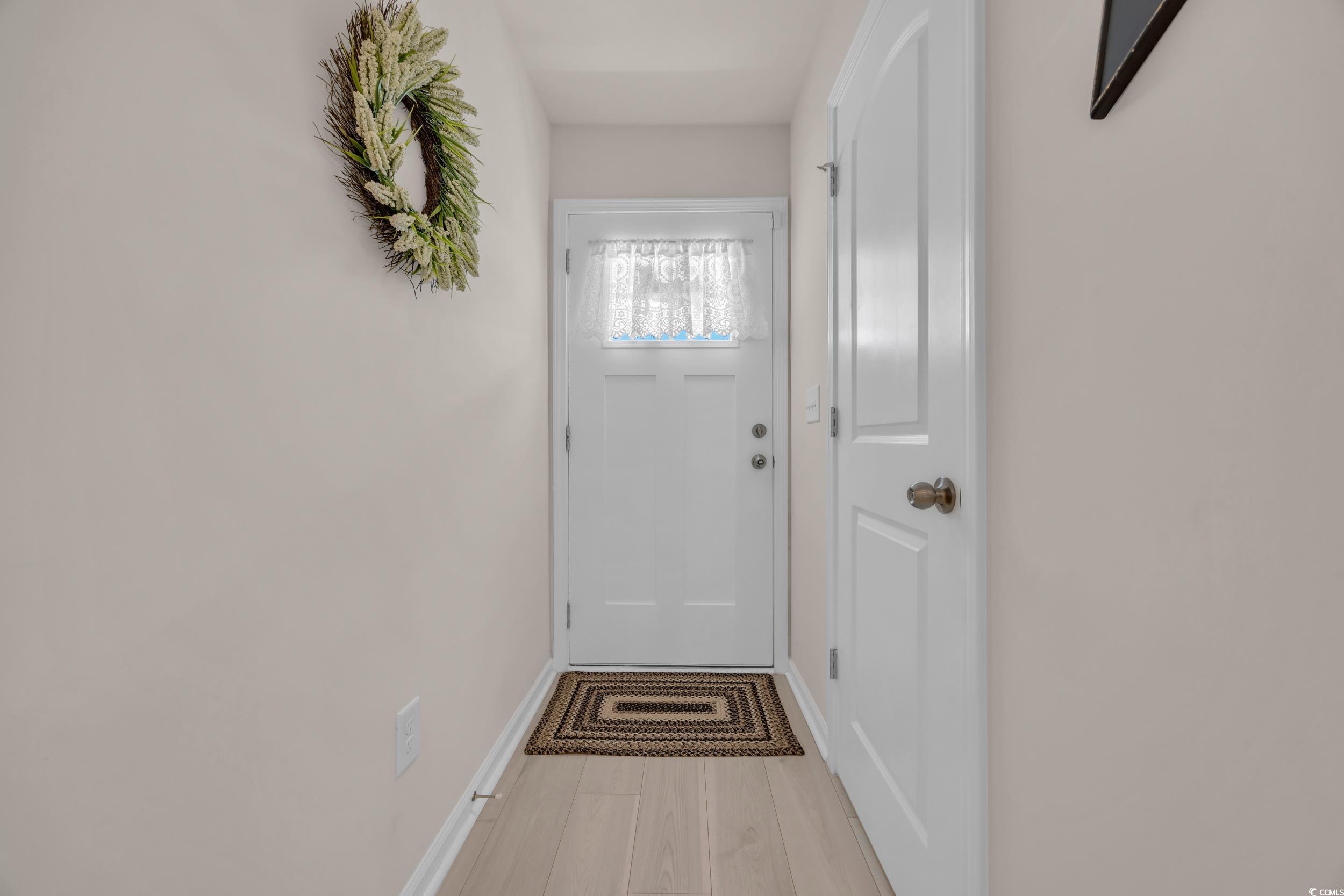 132 Machrie Loop, Unit A Myrtle Beach, SC 29588 - Photo 5 of 25 Doorway to outside featuring baseboards and wood finished floors