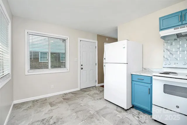 a white refrigerator freezer and a stove sitting inside of a kitchen